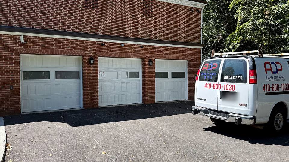 ADP Garage Door Repair van at a three door brick garage