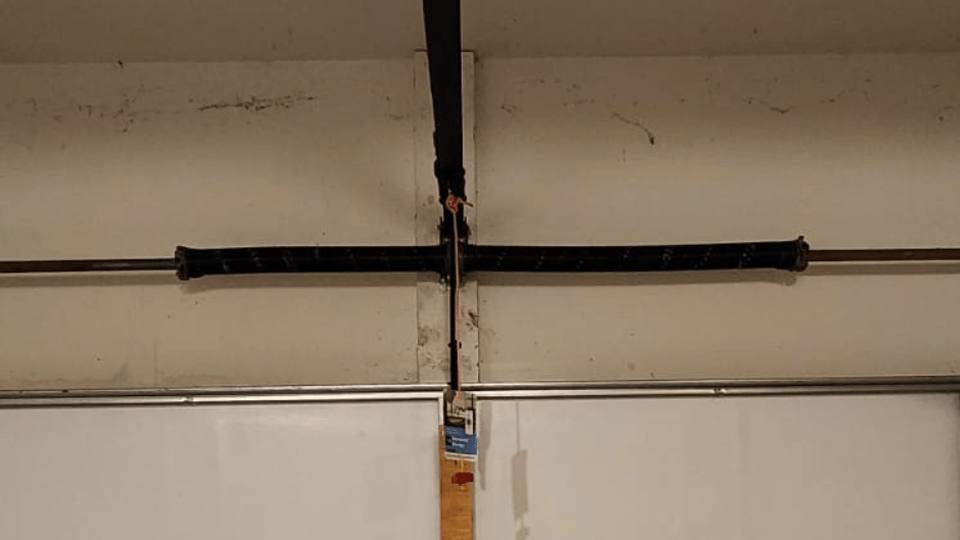 Two new torsion springs installed on the shaft above a garage door