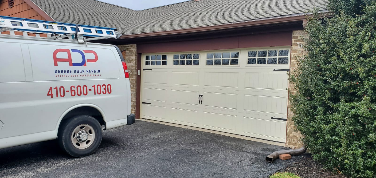 ADP Garage Door Repair van parked by a two car garage door