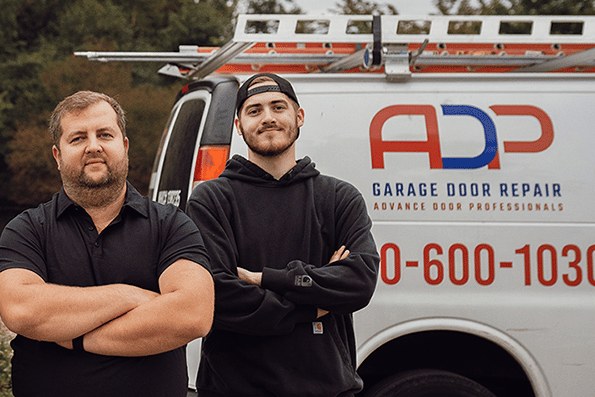 Dima and Jake of ADP Garage Door Repair in front of a company van