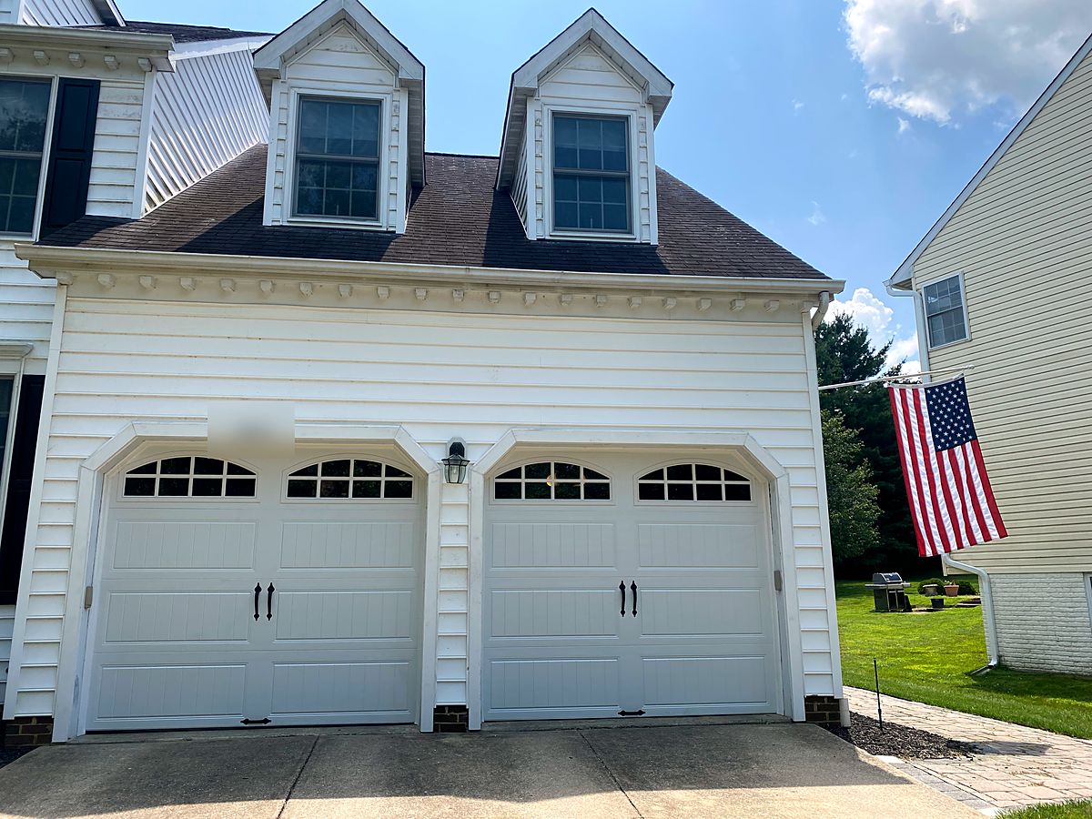 Two white carriage house garage doors with arched windows in Clarksville