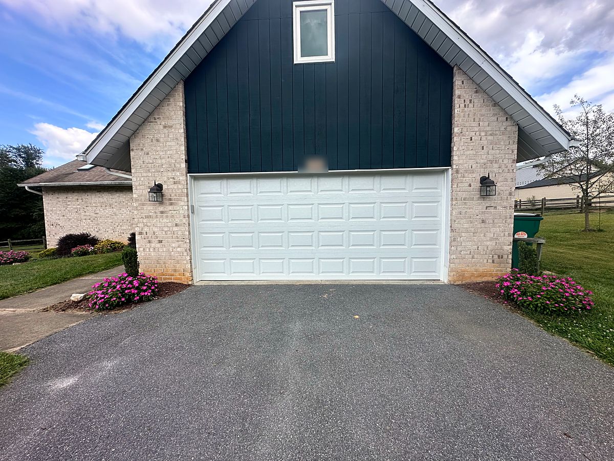 White raised panel double garage door on a brick and board home in Marriottsville